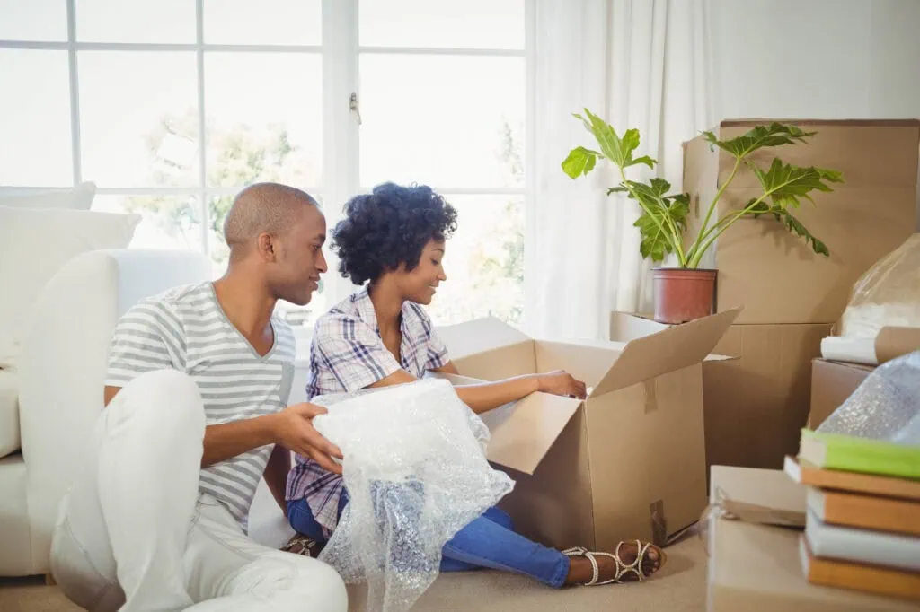 happy couple opening boxes in the living room