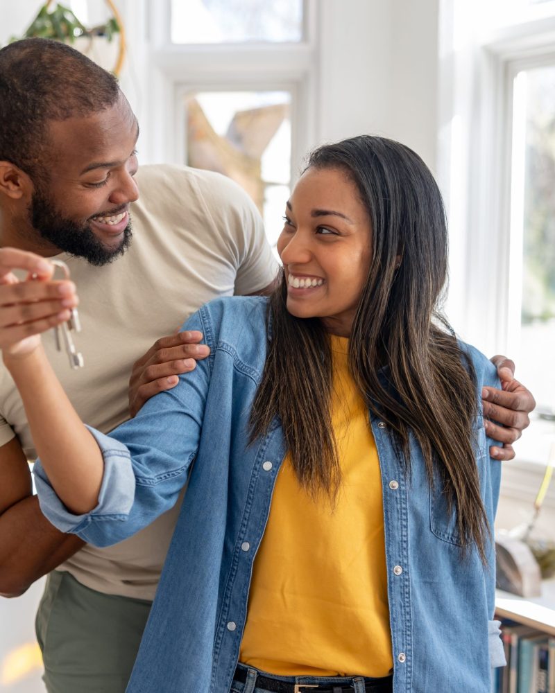 couple looking very happy holding the keys of their new house